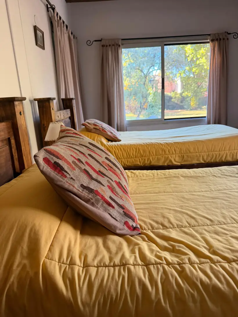Habitación con dos camas y ventanal al jardín